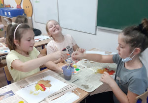 Uczennice klasy III i I podczas malowania pejzaży jesiennych