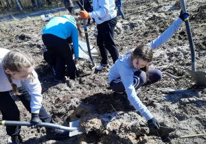 Nadia i Julia sadzą młode drzewko