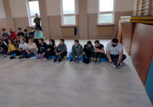Uczniowie klas IV, V i VI z nauczycielem podczas spotkania z policjantami