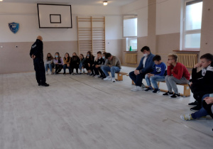 Uczniowie klas VII i VIII z nauczycielem podczas spotkania z policjantami
