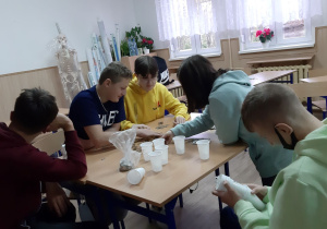 Uczniowie klasy VIII podczas liczenia monet w ramach akcji "Góra Grosza"