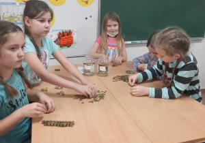 Uczniowie klasy II i III podczas liczenia monet na zajęciach świetlicowych