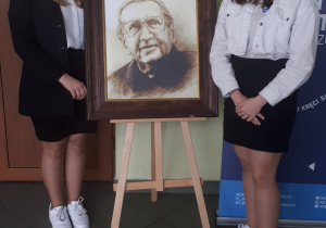Jowita Mazurek i Amelia Bernaciak przy portrecie księdza Jana Twardowskiego