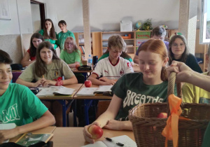 Uczniowie klasy VIII częstujący jabłkami uczniów klasy VII