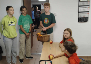 Uczniowie klasy VIII częstujący jabłkami uczniów klasy IV