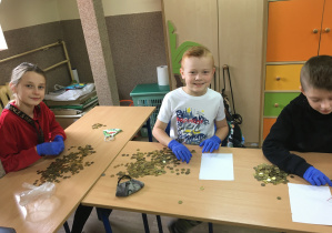 Uczniowie klasy III podczas liczenia monet