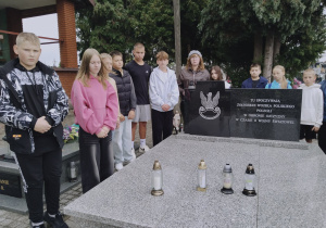 zapalenie zniczy na mogile zbiorowej żołnierzy poległych w obronie Ojczyzny w czasie II wojny światowej