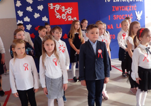 uczniowie klas I - III podczas śpiewania hymnu państwowego