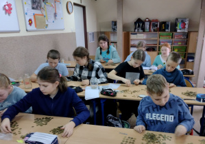 Uczniowie klasy V podczas liczenia monet w ramach akcji "Góra Grosza"